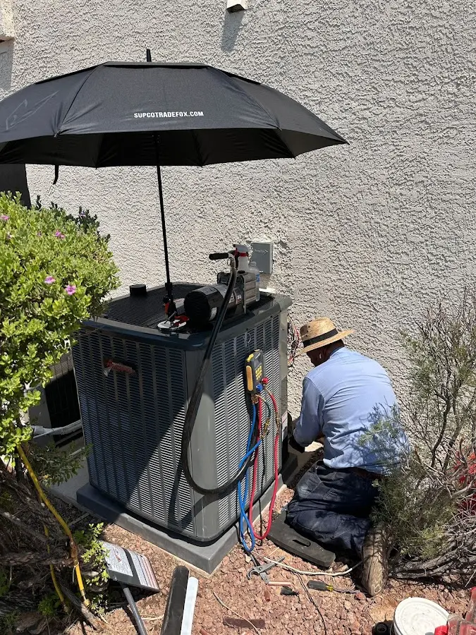 HVAC technician performing outdoor AC maintenance in Oxford